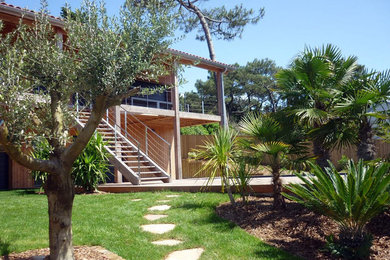 Aménagement d'un jardin avant bord de mer de taille moyenne et l'été avec une exposition ensoleillée et une terrasse en bois.