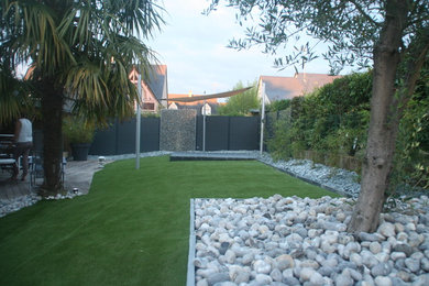 Exemple d'un petit jardin arrière tendance avec une exposition ensoleillée et une terrasse en bois.