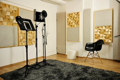 Foto de estudio bohemio pequeño con paredes amarillas, suelo de madera oscura y escritorio empotrado