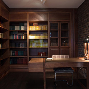 Inspiration för mycket stora moderna hemmabibliotek, med bruna väggar, ett fristående skrivbord, laminatgolv och brunt golv