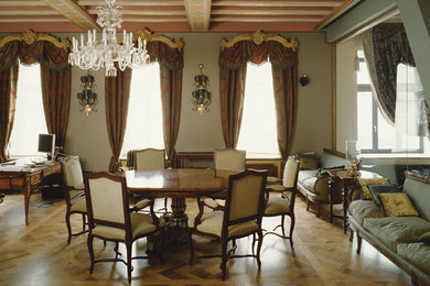 Aménagement d'une grande salle à manger classique avec un mur vert et un sol en bois brun.