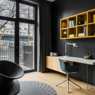 Idéer för ett mellanstort modernt hemmabibliotek, med svarta väggar, ljust trägolv, ett inbyggt skrivbord och beiget golv