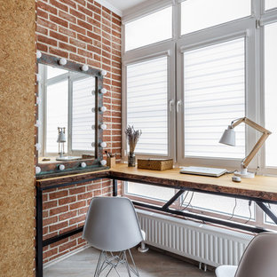 Idée de décoration pour un bureau bohème avec un mur rouge, un bureau indépendant et un sol gris.
