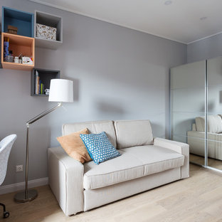 Idée de décoration pour un bureau design de taille moyenne et de type studio avec un mur gris, un sol en bois clair, un bureau indépendant et un sol turquoise.