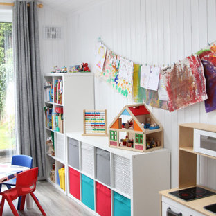 Inspiration för små moderna könsneutrala småbarnsrum kombinerat med lekrum, med vita väggar, laminatgolv och grått golv