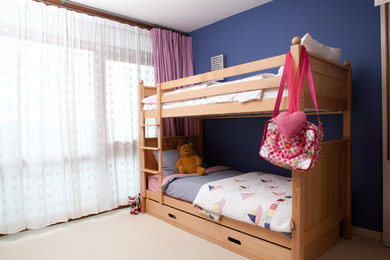 Design ideas for a small contemporary children’s room for girls in London with blue walls, carpet and beige floors.