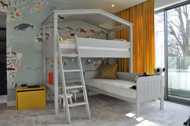 Imagen de dormitorio infantil actual con paredes multicolor, moqueta y suelo beige