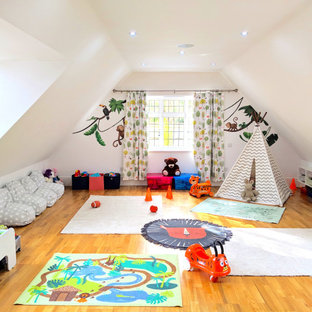Idee per una grande cameretta per bambini da 1 a 3 anni boho chic con pareti bianche e pavimento in laminato
