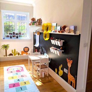 Cette image montre une grand chambre d'enfant de 1 à 3 ans bohème avec un mur blanc et sol en stratifié.