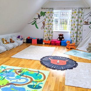Esempio di una grande cameretta per bambini da 1 a 3 anni boho chic con pareti bianche e pavimento in laminato