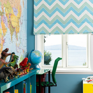This is an example of a medium sized contemporary kids' study space for boys with blue walls, light hardwood flooring and beige floors.