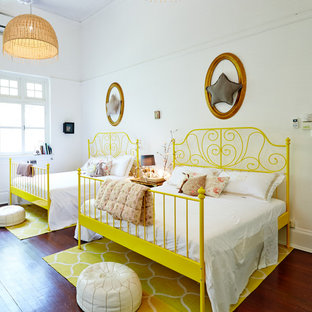 Photo of a world-inspired kids' bedroom with white walls, medium hardwood flooring and brown floors.
