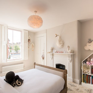 Design ideas for a medium sized traditional children’s room for girls in London with grey walls, carpet and beige floors.
