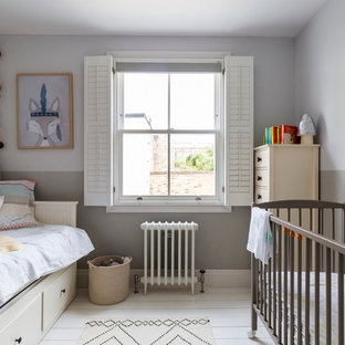Foto di una cameretta per bambini da 1 a 3 anni scandinava di medie dimensioni con pavimento in legno verniciato, pareti multicolore e pavimento bianco