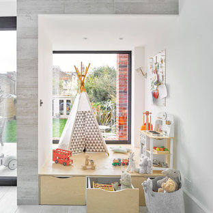 This is an example of a scandinavian gender neutral kids' bedroom in London with white walls and grey floors.