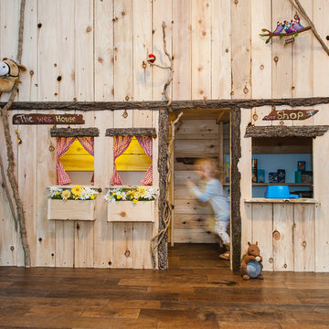 Indoor forest cottage playroom with giant blackboard and rustic storage
