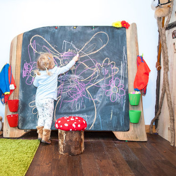 Indoor forest cottage playroom with giant blackboard and rustic storage