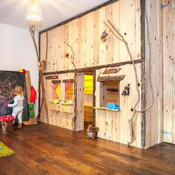 Indoor forest cottage playroom with giant blackboard and rustic storage