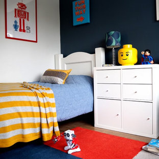 Foto di una cameretta per bambini da 4 a 10 anni minimal di medie dimensioni con pareti blu e pavimento in laminato
