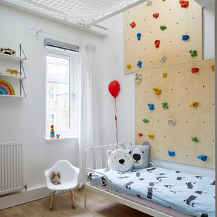 Small scandi kids' bedroom in London with multi-coloured walls and light hardwood flooring.