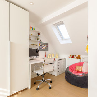 Esempio di una cameretta per bambini design con pareti bianche, parquet chiaro e pavimento beige