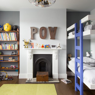 Medium sized contemporary children’s room for boys in London with grey walls, dark hardwood flooring and brown floors.
