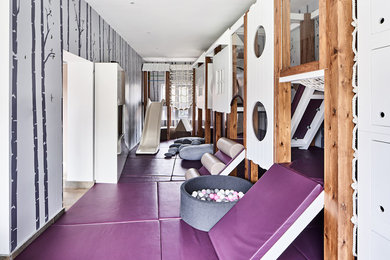 This is an example of a medium sized contemporary gender neutral kids' bedroom in Manchester with grey walls and purple floors.