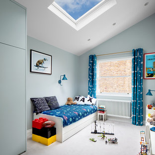 This is an example of a contemporary kids' bedroom in London with blue walls, carpet and grey floors.
