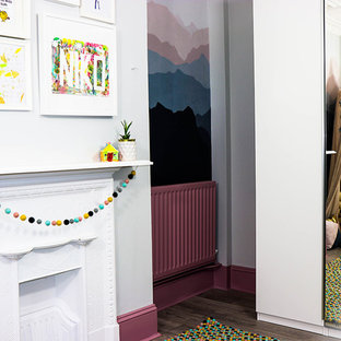 Esempio di una cameretta per bambini da 4 a 10 anni minimal di medie dimensioni con pareti grigie, pavimento in laminato e pavimento grigio