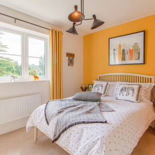 Medium sized classic gender neutral children’s room in Gloucestershire with yellow walls, carpet and beige floors.