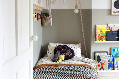 Scandinavian toddler’s room for boys in London with grey walls, painted wood flooring and grey floors.