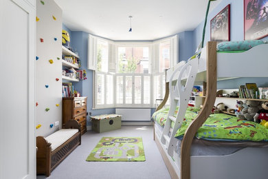 Medium sized bohemian children’s room for boys in London with blue walls, carpet and grey floors.