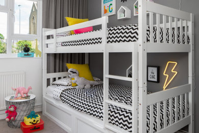 This is an example of a small contemporary gender neutral children’s room in London with grey walls and grey floors.