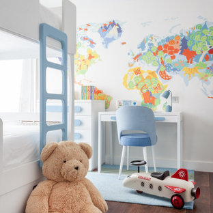 Contemporary children’s room for boys in London with multi-coloured walls, dark hardwood flooring and brown floors.