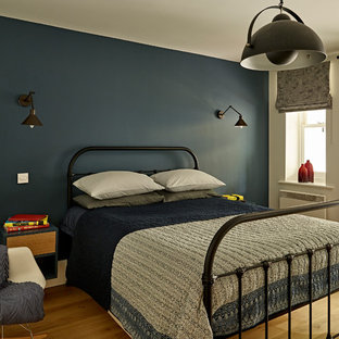 This is an example of a medium sized contemporary teen’s room for boys in London with blue walls, light hardwood flooring and beige floors.