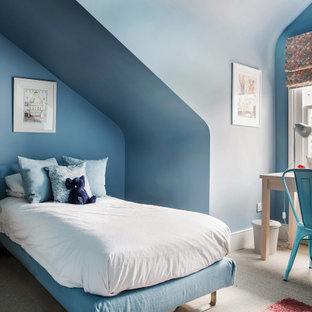 Photo of a contemporary kids' bedroom for boys in London with blue walls, carpet, beige floors and a vaulted ceiling.