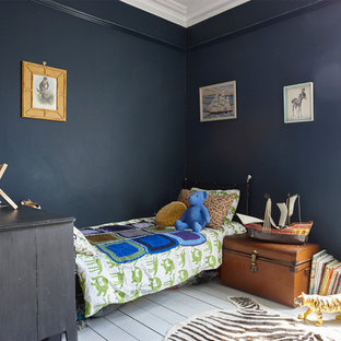 Cette photo montre une grand chambre d'enfant de 4 à 10 ans victorienne avec un mur bleu et un sol en bois peint.
