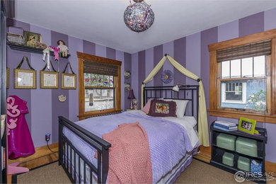 Ejemplo de dormitorio infantil de 4 a 10 años de estilo americano de tamaño medio con paredes púrpuras y suelo de madera clara