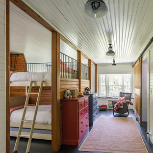 Immagine di una cameretta per bambini da 4 a 10 anni country con pareti bianche, parquet scuro, pavimento nero, soffitto in perlinato e pareti in perlinato