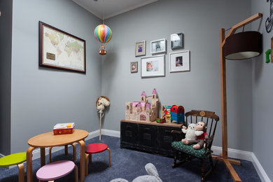 Photo of a small eclectic gender neutral kids' bedroom in New York with blue walls and carpet.