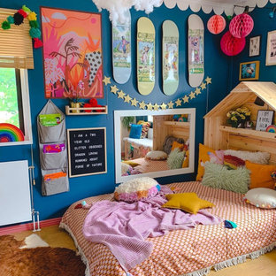 This is an example of an eclectic kids' room for girls in Melbourne with blue walls, medium hardwood floors and brown floor.
