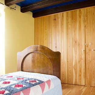 Tuscan boy medium tone wood floor kids' bedroom photo in Other with yellow walls