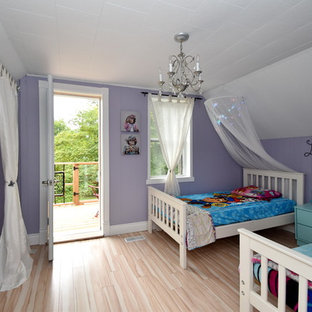 Immagine di una grande cameretta per bambini da 4 a 10 anni country con pareti viola, pavimento in laminato e pavimento beige