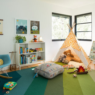 Example of a 1950s gender-neutral medium tone wood floor kids' room design in Denver with white walls