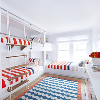 Mid-sized beach style gender-neutral light wood floor kids' room photo in New York with white walls