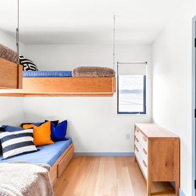Inspiration for a mid-sized contemporary boy medium tone wood floor and brown floor kids' room remodel in New York with white walls