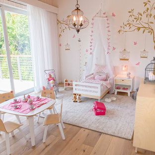 Ispirazione per una grande cameretta per bambini da 1 a 3 anni costiera con pareti rosa e pavimento in legno massello medio