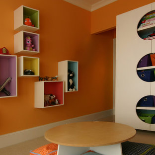 Esempio di una cameretta per bambini da 4 a 10 anni design di medie dimensioni con pareti arancioni e moquette