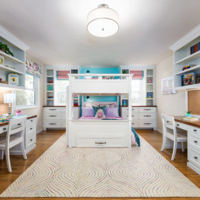 Transitional medium tone wood floor and brown floor kids' bedroom photo in San Francisco with beige walls
