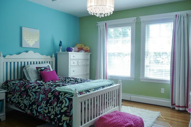 Medium sized bohemian teen’s room for girls in Boston with multi-coloured walls and light hardwood flooring.